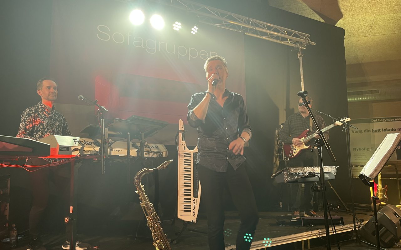 Sofagruppen på scenen med saxofon, keytar og guitar