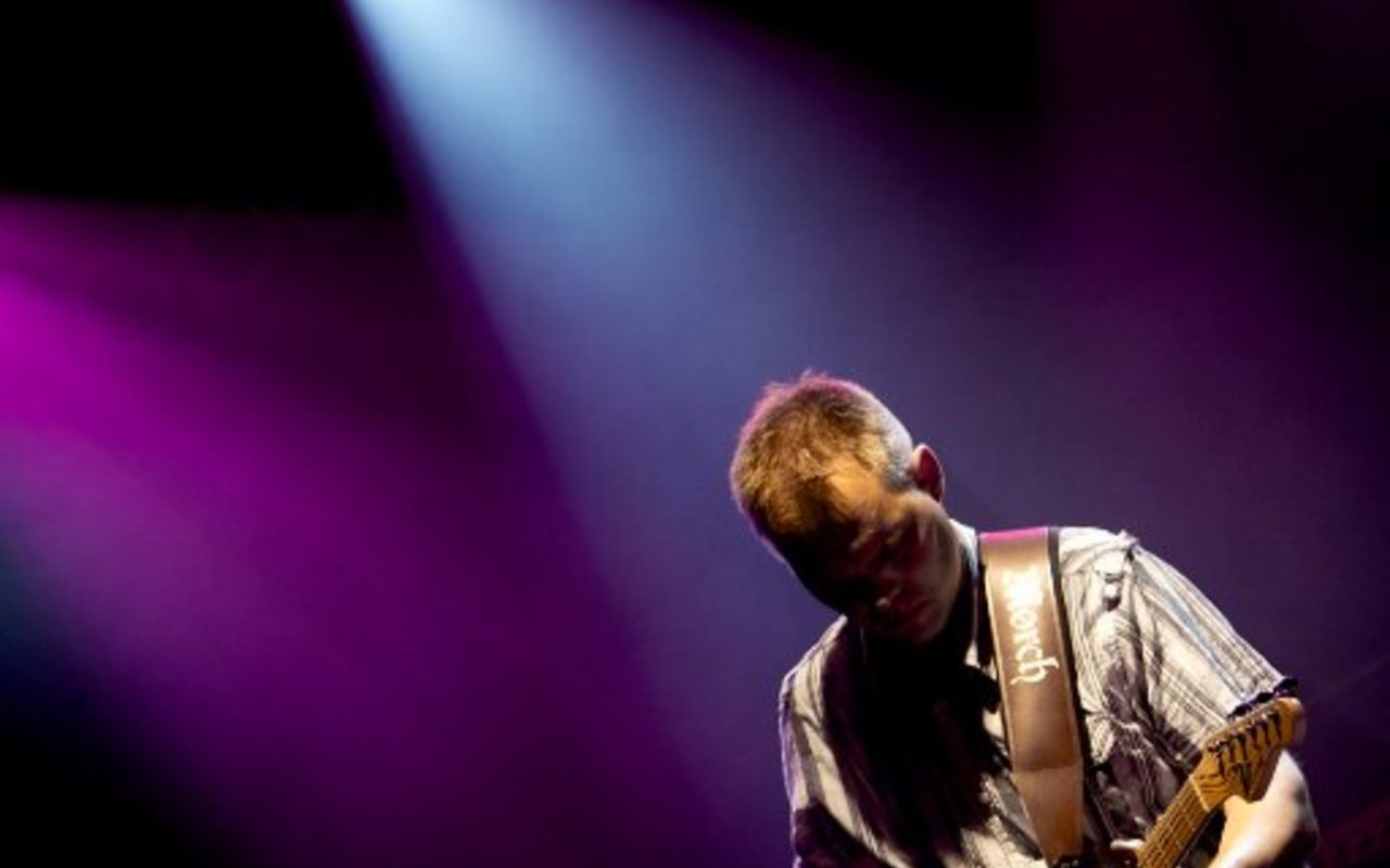 Guitarist i lyskegle på scenen